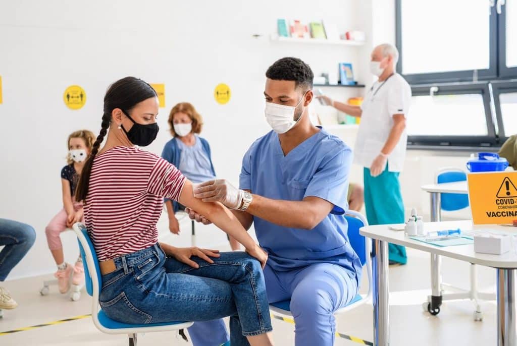 Woman with face mask getting vaccinated